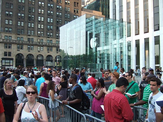 "Line at Apple Store in NYC" by Rob DiCaterino from Jersey City, NJ, USA - Apple Store, 5th Ave., NYC, 7/12/08 - 13 of 19Uploaded by Allmightyduck. Licensed under CC BY 2.0 via Wikimedia Commons