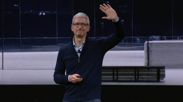 Apple CEO Tim Cook waves goodbye to the assembled press and employees