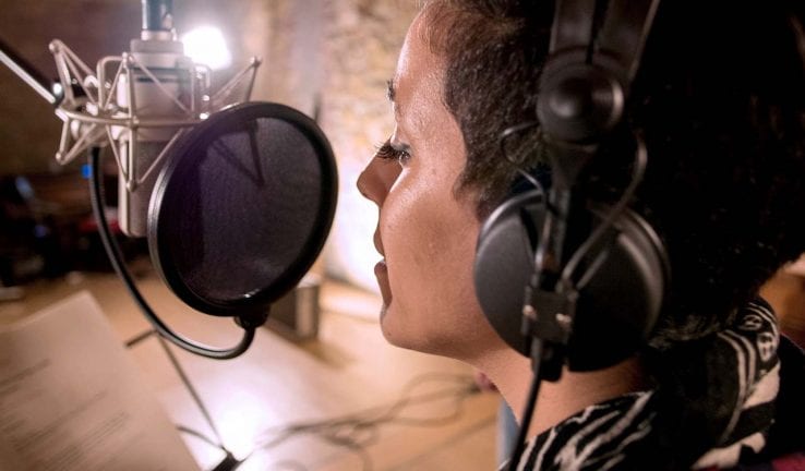 Woman singing on a microphone in a studio