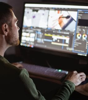 man siting in front of a computer editing a video