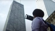 Portrait of a student filming the John hancock Center in Chicago