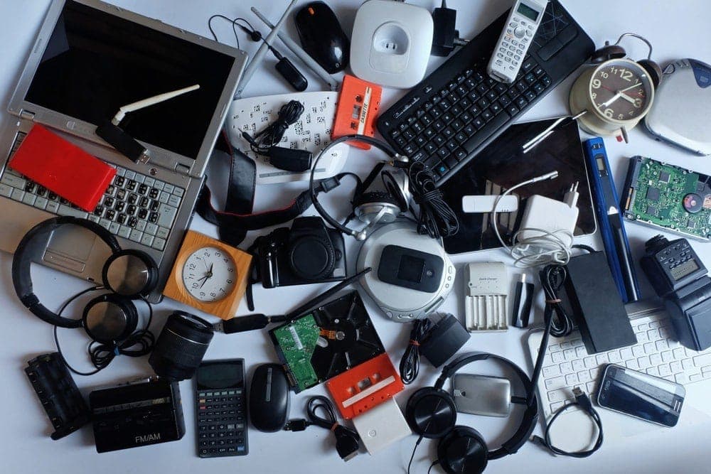 old electronics, phones, computers, headphones, cameras in a pile - recycle, discard