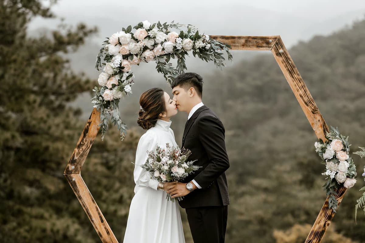 Young couple kissing at an outdoor wedding in the mountains