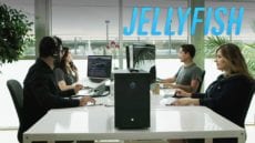 Four people sitting at a table working on editing a video with a Jellyfish Video system