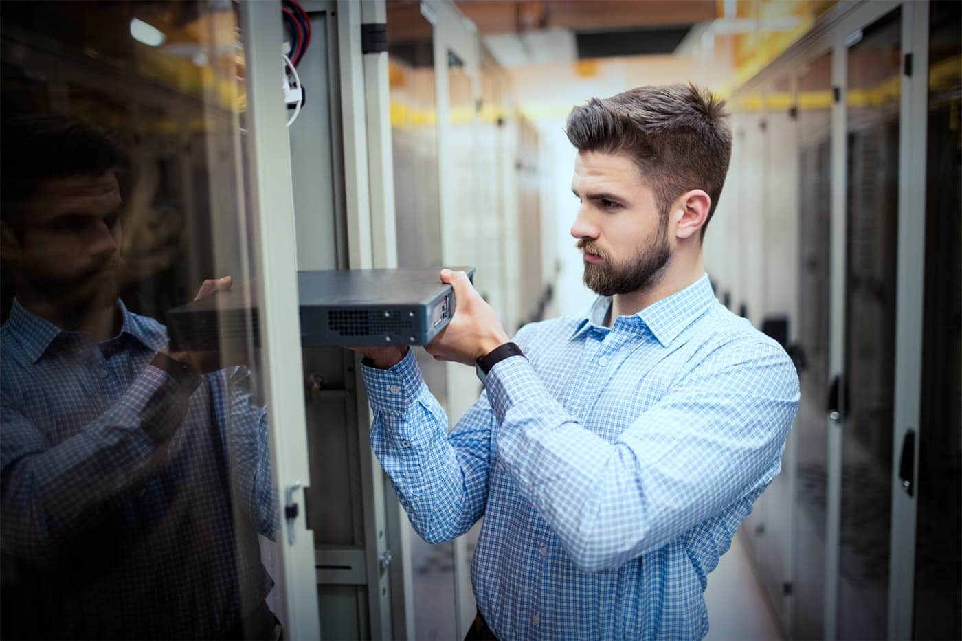 A man putting a server into a datacenter rack