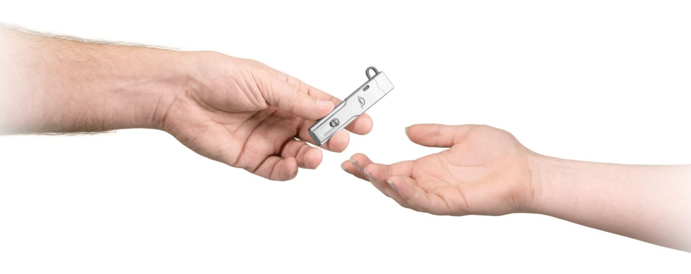 OWC Envoy Pro mini USB drive being handed from one person to another.
