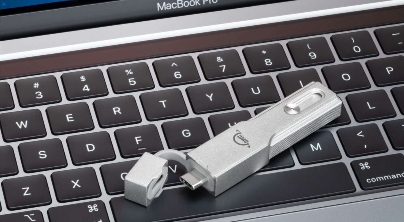 OWC Envoy Pro mini rests on a MacBook Pro keyboard.
