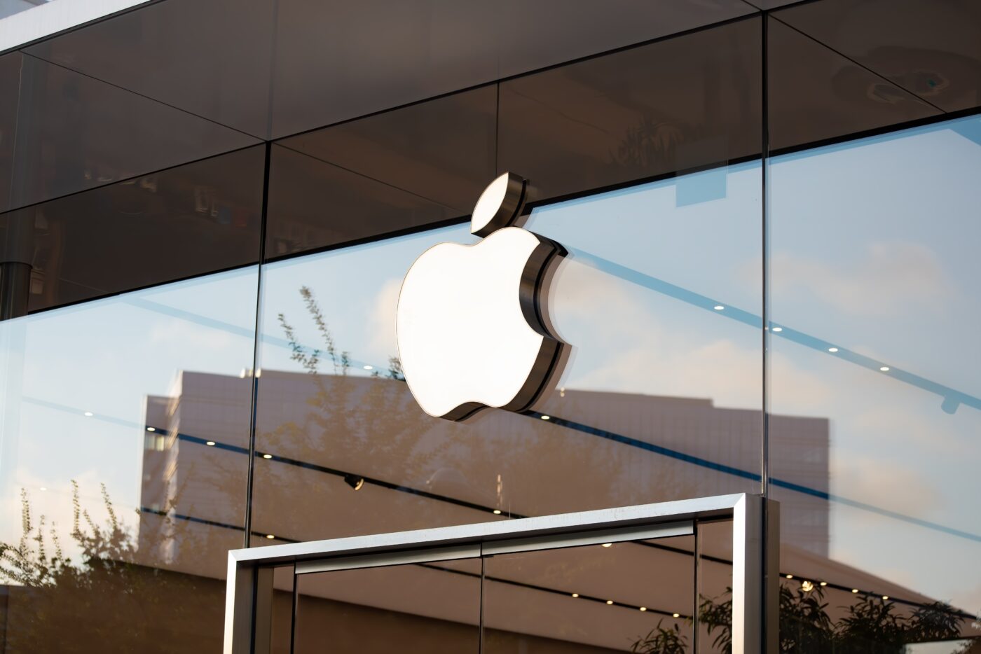 The Apple Logo over the doorway of an Apple retail store.