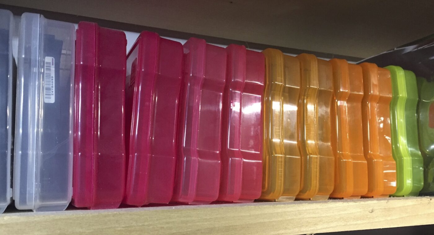 Transparent colorful storage boxes on a shelf.