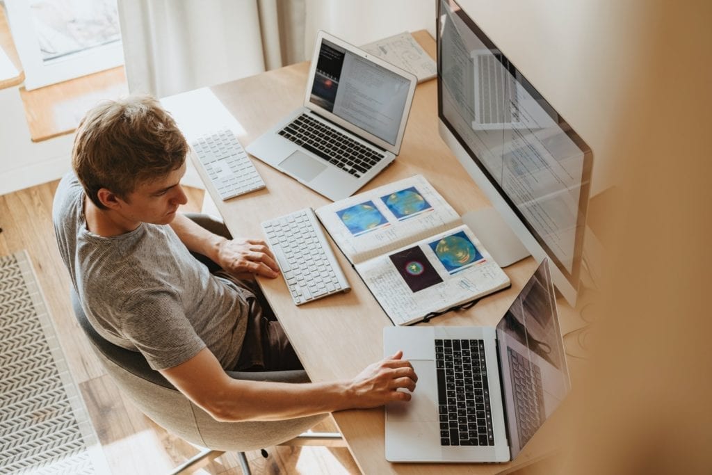 Man on three computers