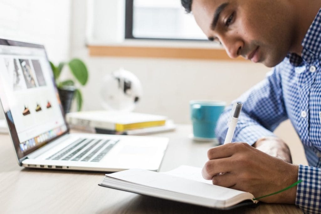 Man using a pen writing on paper